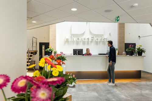 Medewerker van HilverdaFlorist in gesprek met de receptionist bij de receptie