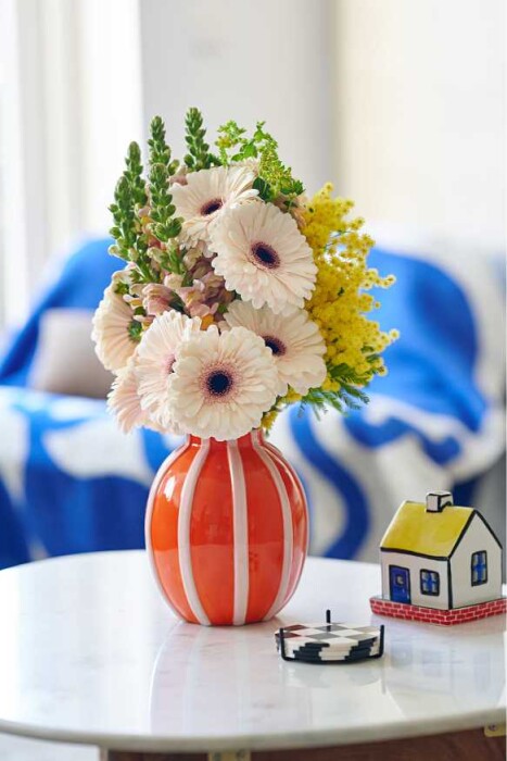 Sfeerfoto van Gerbera Standard Truffle van HilverdaFlorist. Een zachtroze Gerbera met een donkerroze ring rond het zwarte hart.