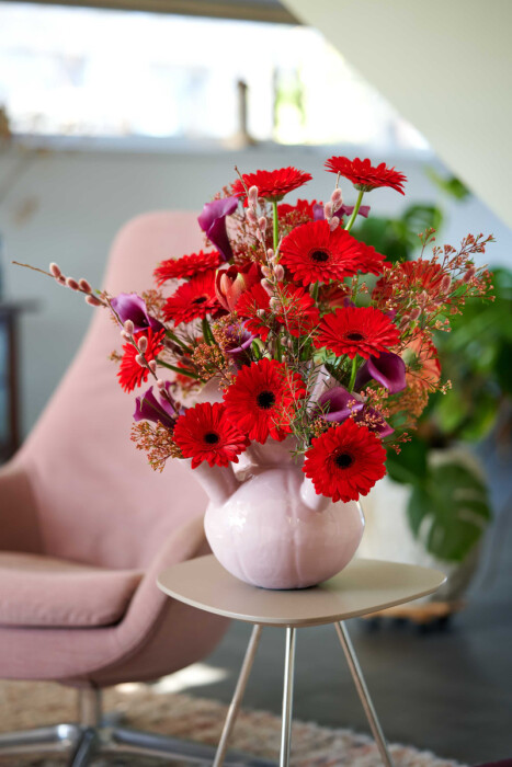 Sfeerfoto van Gerbera Standard Flamboyance van HilverdaFlorist. Een dieprode Gerbera met veel bloemblaadjes en uitstekende kwaliteit.